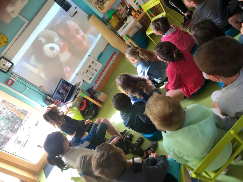 une classe d'enfants regarde une image projetée sur un tableau